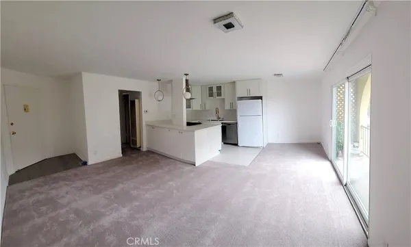 a view of a kitchen with refrigerator and window