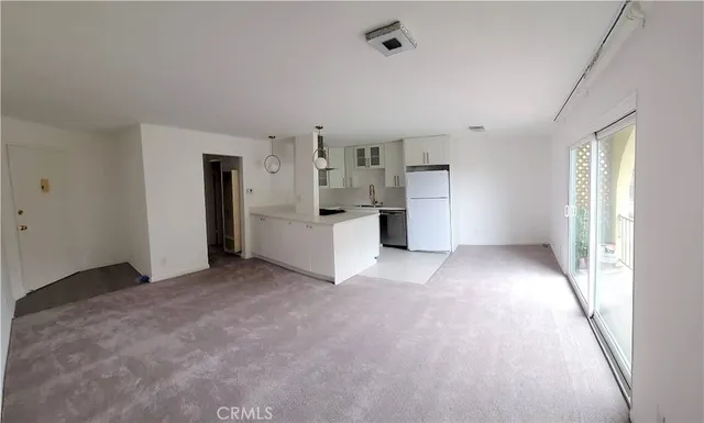 a view of a kitchen with refrigerator and window