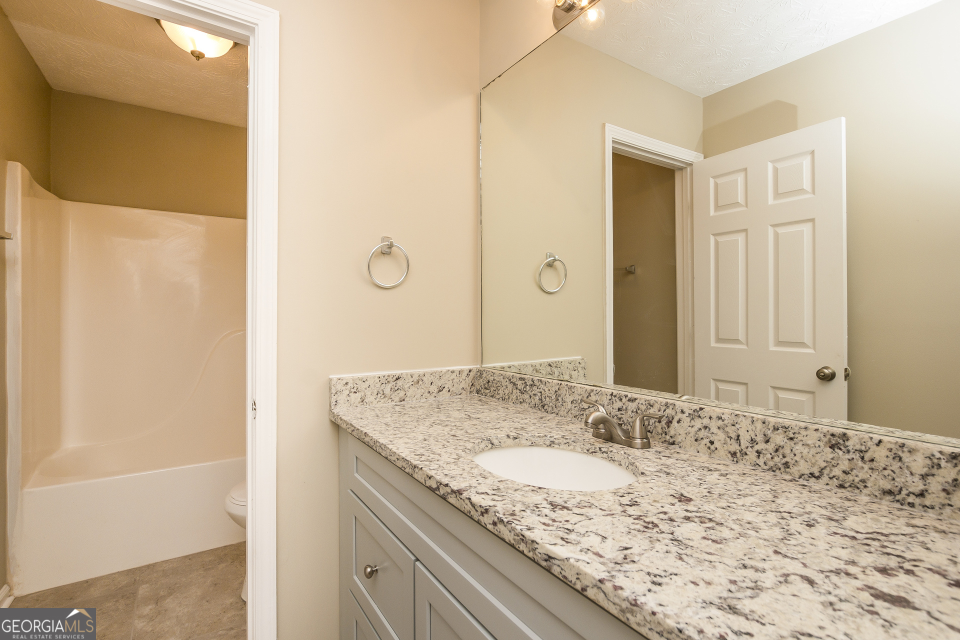 7287 Walton Hill Fairburn, GA 30213 - Photo 11 of 15 a bathroom with a granite countertop sink and a mirror