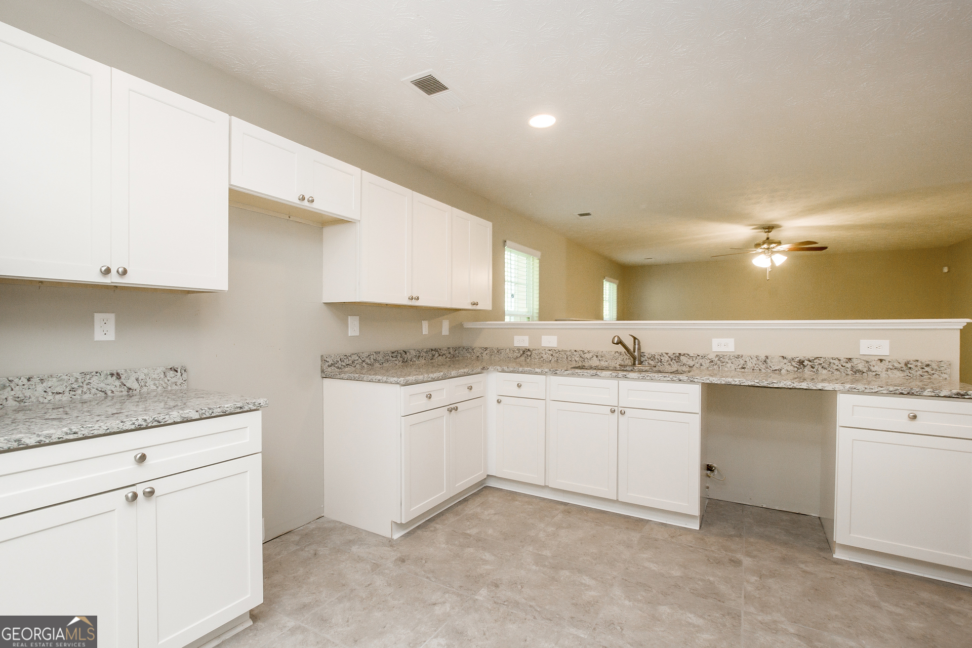 7287 Walton Hill Fairburn, GA 30213 - Photo 5 of 15 a kitchen with a sink dishwasher a stove top oven and white cabinets