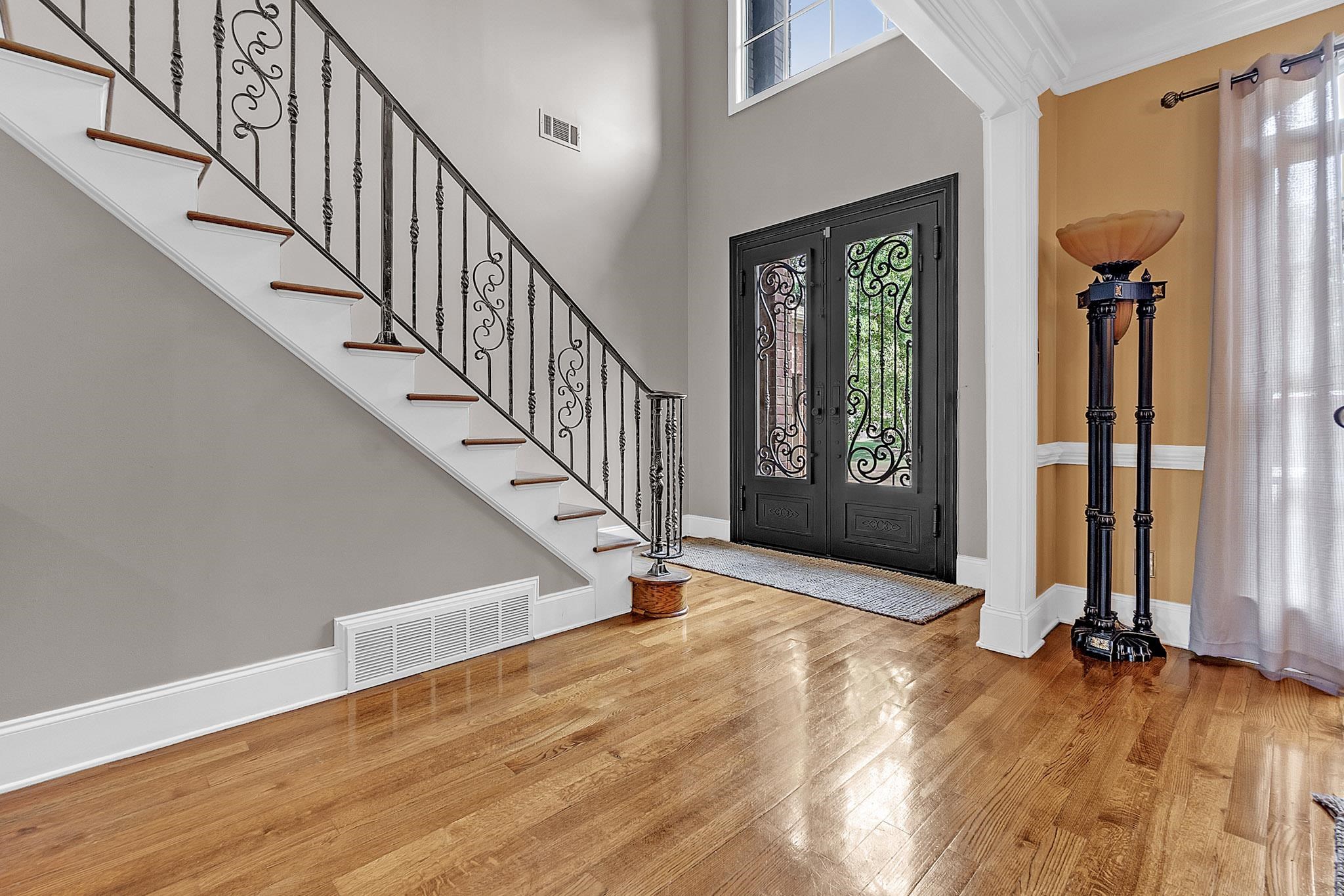 649 Ridge Springs Road Collierville, TN 38017 - Photo 5 of 38 Grand entry featuring wood-finish flooring, a double-height ceiling, and a decorative wrought iron staircase