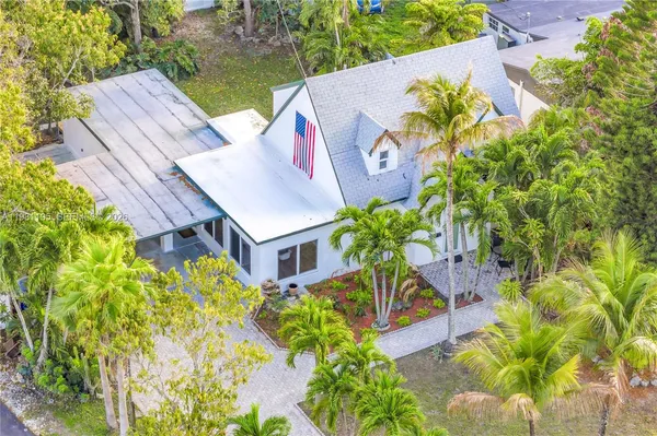 an aerial view of a house with swimming pool and garden