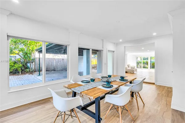 a kitchen with kitchen island a large window cabinets and stainless steel appliances
