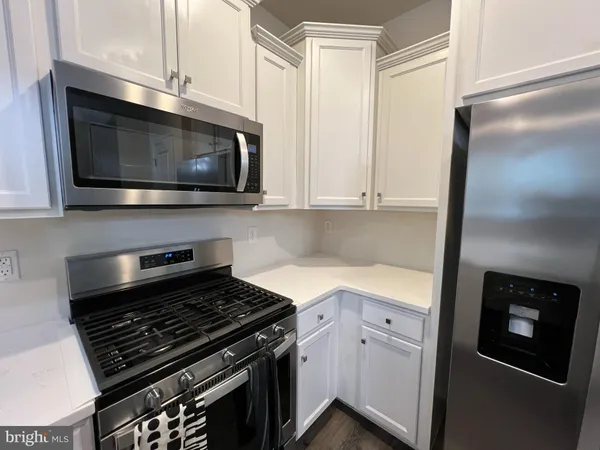 a kitchen with stainless steel appliances granite countertop white cabinets and black stove top oven with granite countertops