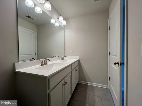 a bathroom with a double vanity sink and a mirror