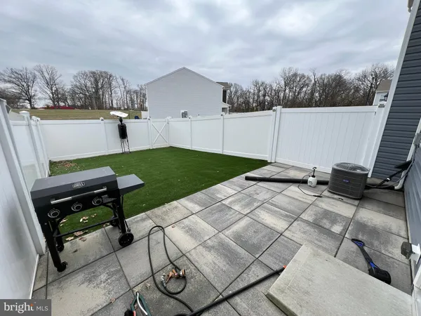 a view of a backyard with furniture and a grill