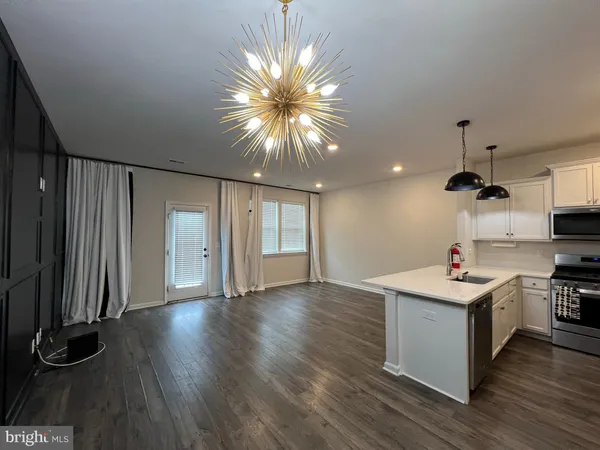 a living room with kitchen island furniture and a ceiling fan