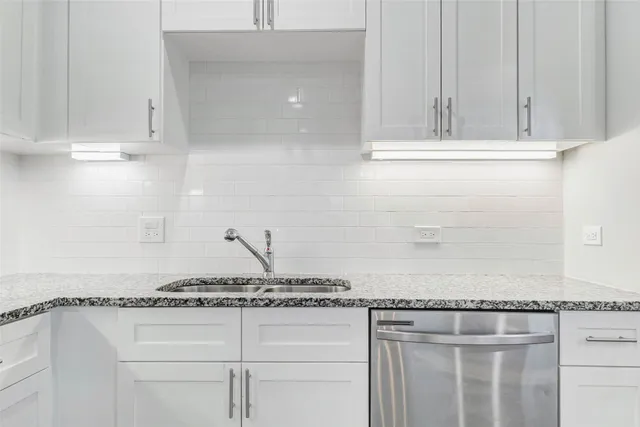 a kitchen with granite countertop white cabinets and white appliances