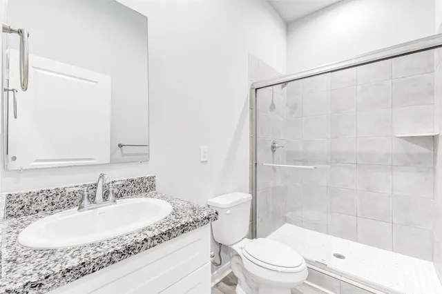 a bathroom with a granite countertop sink toilet and shower