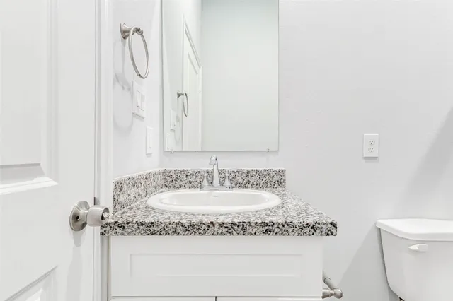 a bathroom with a granite countertop sink and a mirror
