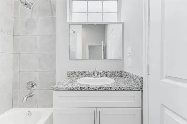 a bathroom with a granite countertop sink and mirror