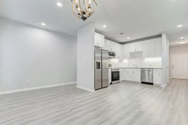 a view of a kitchen with a refrigerator wooden floor and a sink