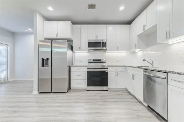 a kitchen with stainless steel appliances a refrigerator stove and microwave