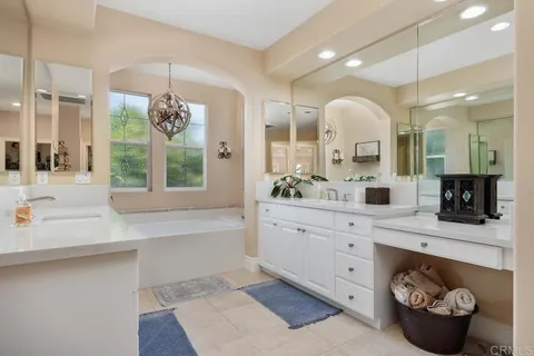 a bathroom with a bathtub a potted plant and a window