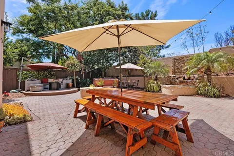 a patio with a table and chairs under an umbrella