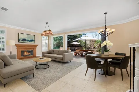 a living room with furniture a chandelier and a fireplace