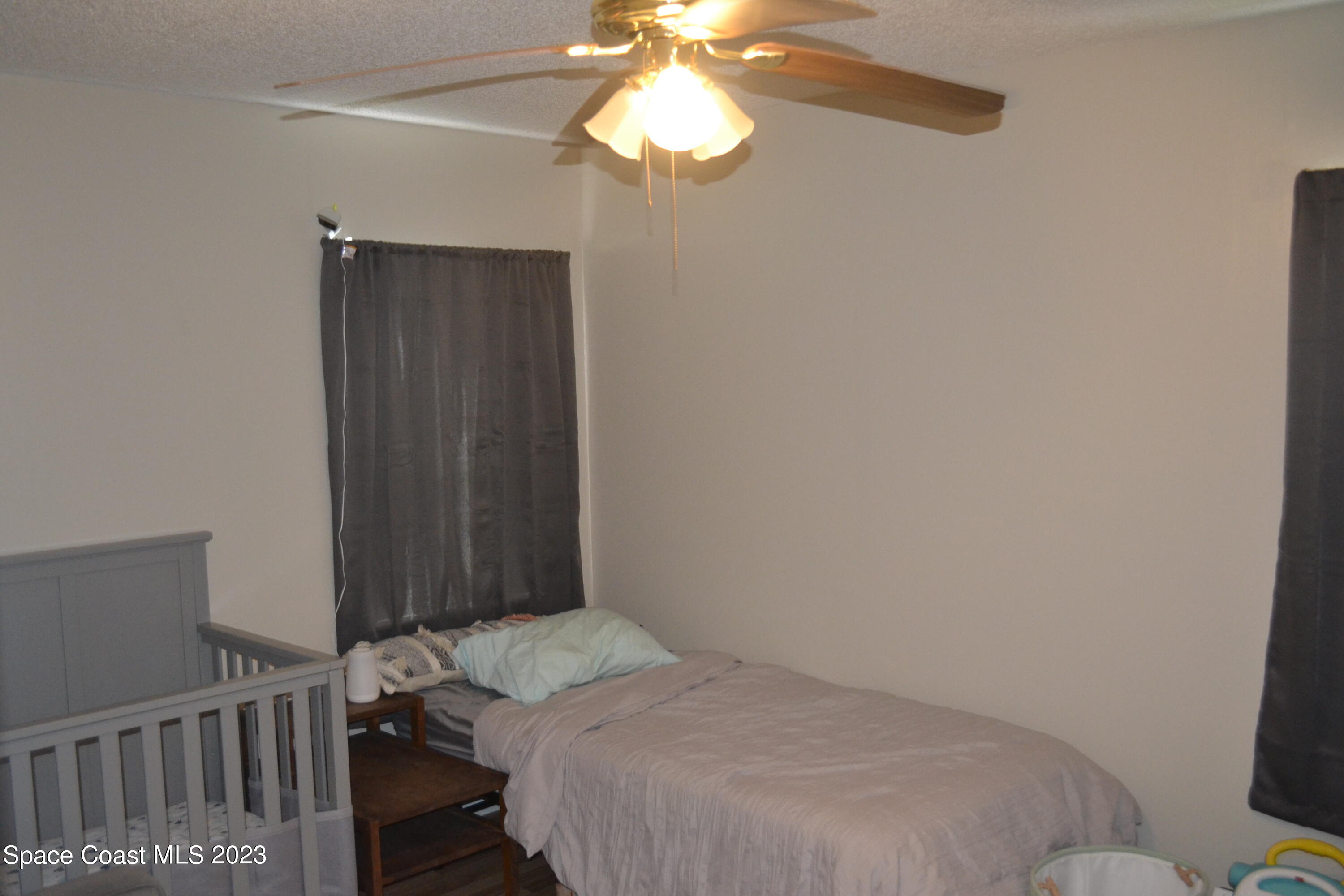 3910 Delespine Road Cocoa, FL 32927 - Photo 15 of 21 a bedroom with a bed and a chandelier