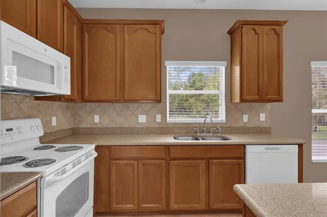 a kitchen with stainless steel appliances granite countertop a sink stove and cabinets