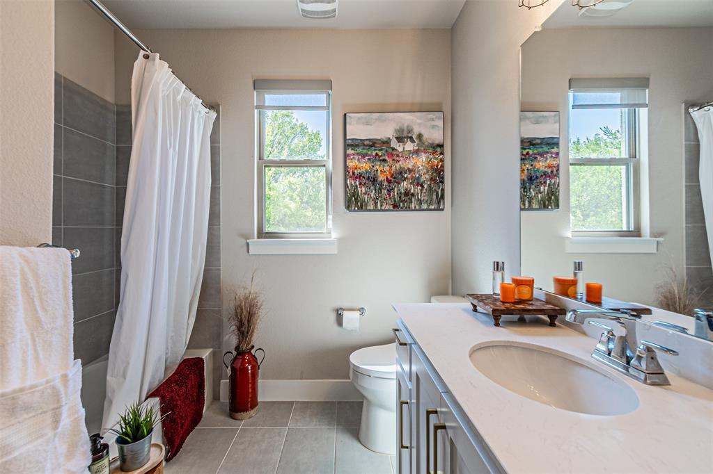 1070 Adair Road Prosper, TX 75078 - Photo 21 of 40 Bathroom featuring a single vanity with an integrated sink, polished chrome faucet, and a large wall-mounted mirror
