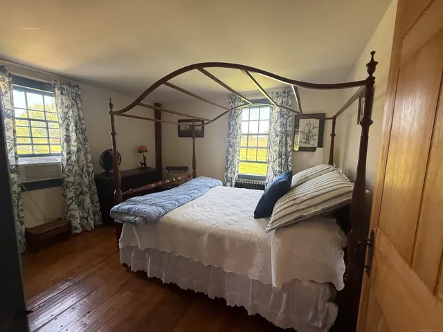 a bedroom with a bed next to a window with the outer view