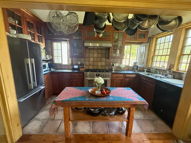 a kitchen with a table chairs a refrigerator and a stove