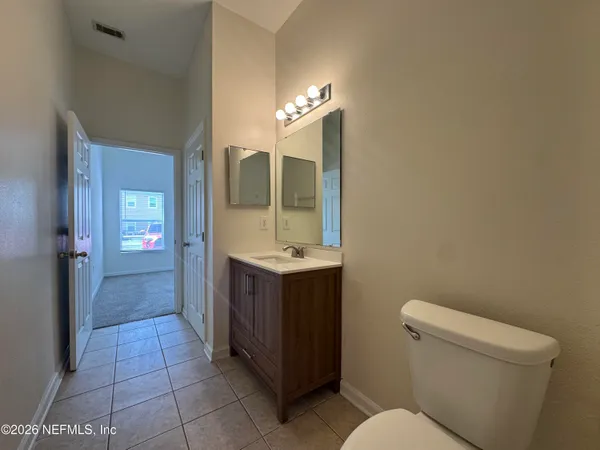 a bathroom with a sink vanity mirror and toilet