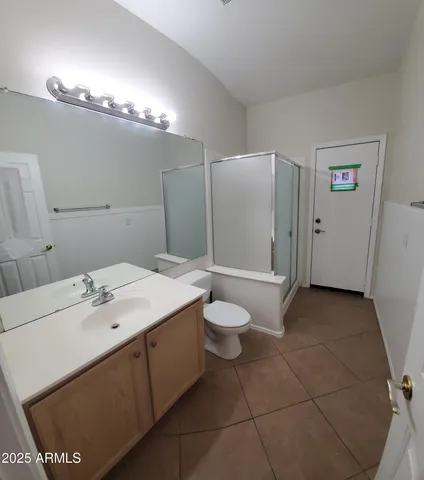 a spacious bathroom with a granite countertop toilet a sink and a bathtub