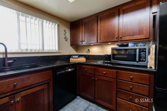 908 North Inyo Street Ridgecrest, CA 93555 - Photo 12 of 46 a kitchen with wooden cabinets and a sink