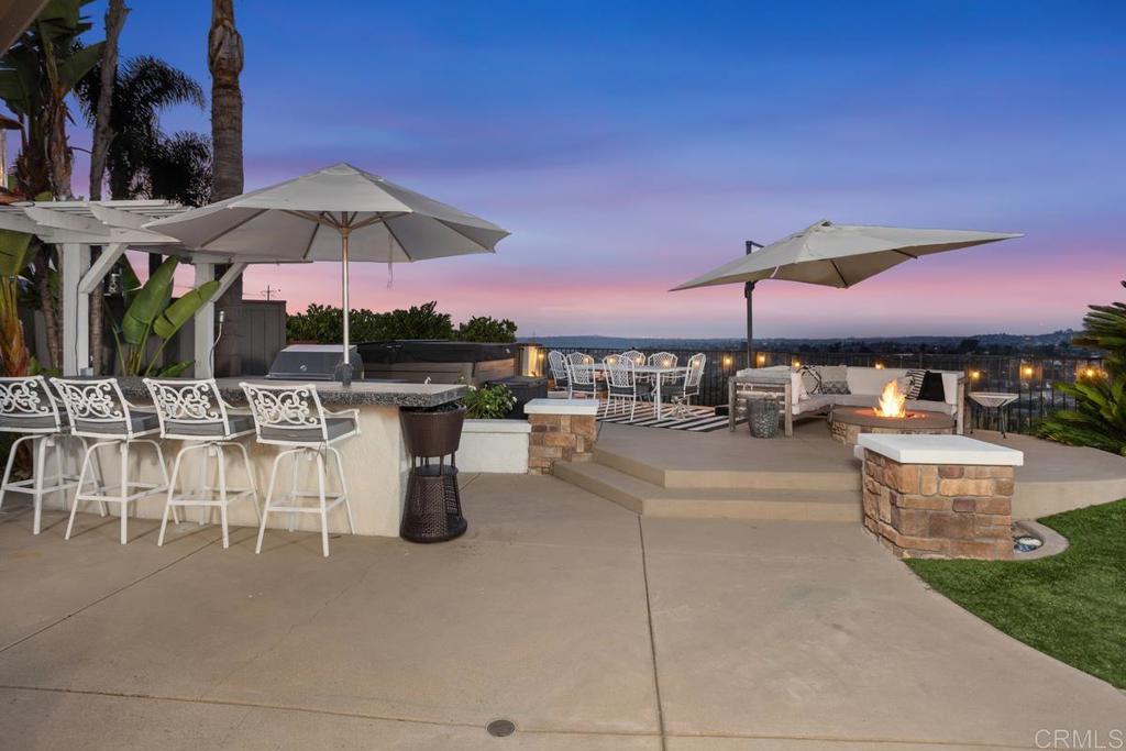 2063 Wandering Road Encinitas, CA 92024 - Photo 23 of 23 a patio with a table and chairs under an umbrella
