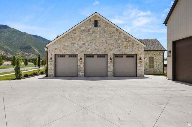 478 South Maple Lakes Drive Mapleton, UT 84664 - Photo 44 of 51 Stone facade garage with three carriage-style doors and exterior sconce lighting