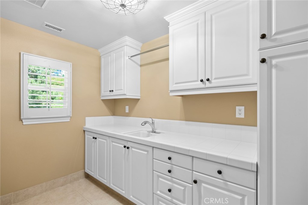 2 Ali Lane Ladera Ranch, CA 92694 - Photo 50 of 75 upstairs laundry room with utility sink and custom cabinetry