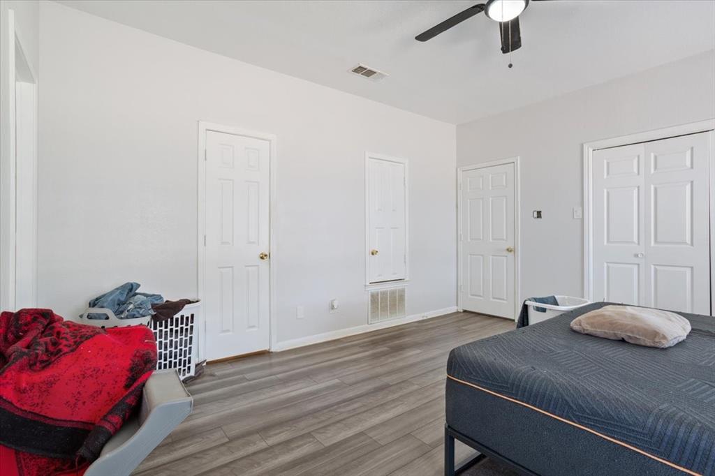 410 State School Road Gatesville, TX 76528 - Photo 28 of 39 Wood-finish flooring, white walls, white paneled doors, and a ceiling fan with integrated lighting