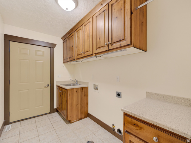1279 West 1500th Street North Mapleton, UT 84664 - Photo 33 of 83 Utility room featuring wood cabinetry, a utility sink, and tiled flooring