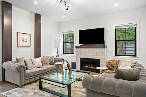 a living room with furniture kitchen view and a chandelier