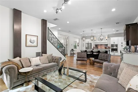 a kitchen with stainless steel appliances a dining table chairs and wooden floor