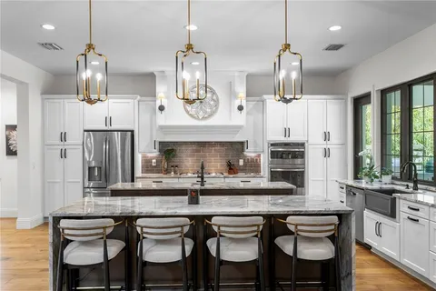 a large kitchen with granite countertop counter space a sink appliances and cabinets