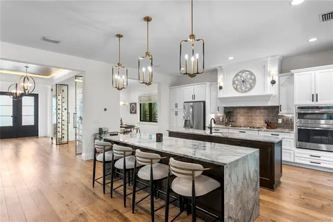 a kitchen with stainless steel appliances granite countertop a stove a sink and a wooden floors