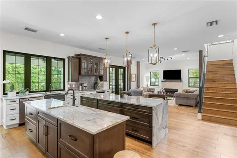 a kitchen with kitchen island granite countertop a sink a stove and a refrigerator