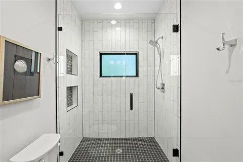 a bathroom with a granite countertop sink toilet a large mirror and shower