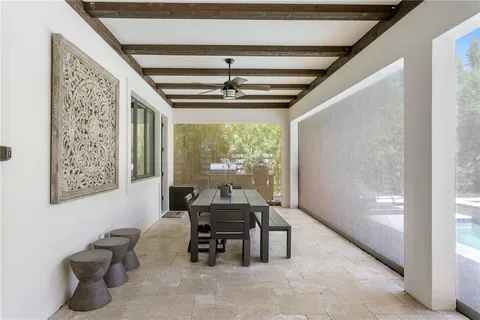 a view of a patio with couches table and chairs with wooden fence and plants