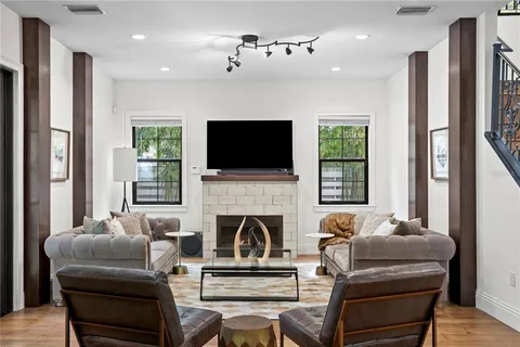 a living room with furniture a flat screen tv and a fireplace