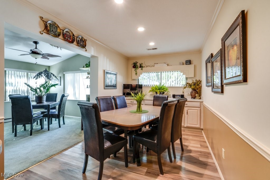 3404 South Smith Road Fairlawn, OH 44333 - Photo 15 of 37 Eat in Kitchen has a bit of its own glamour with luxury vinyl flooring, custom cabinets,, and recessed lighting. This picture gives a hint of the side 4 season sunroom with a card table area, large windows and ceiling fan.