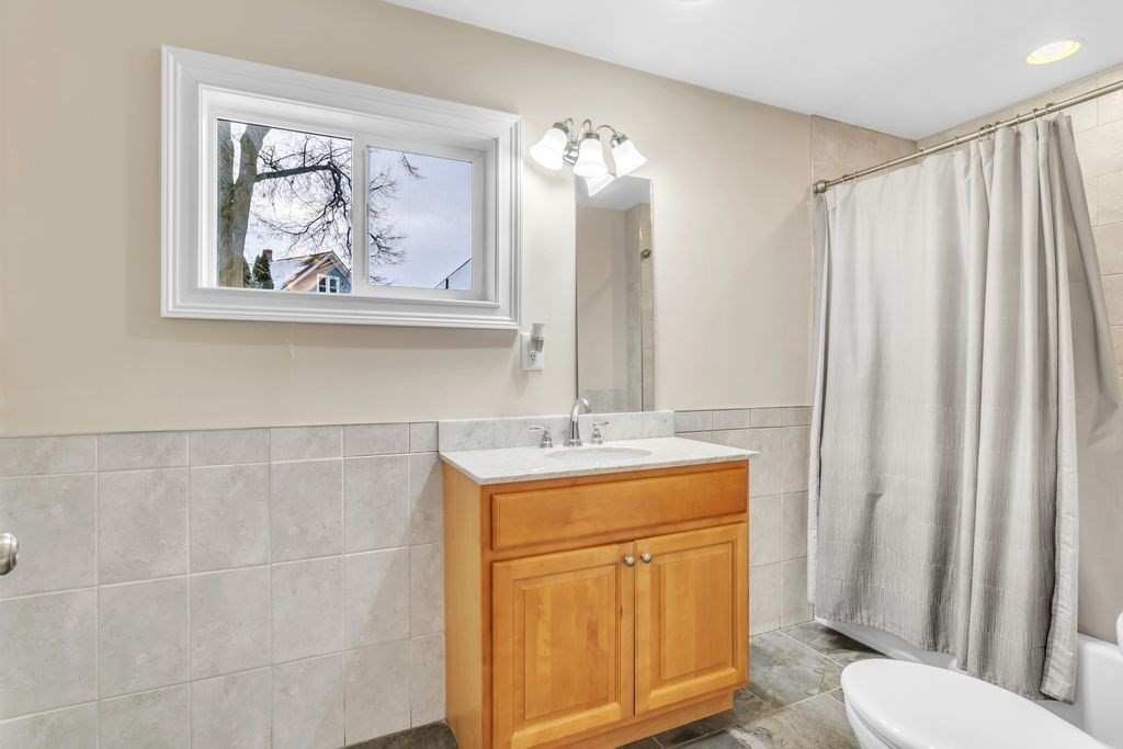754 White Street Springfield, MA 01108 - Photo 36 of 41 a bathroom with a granite countertop sink a toilet and a shower curtain