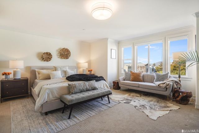 a bedroom with furniture and a large window