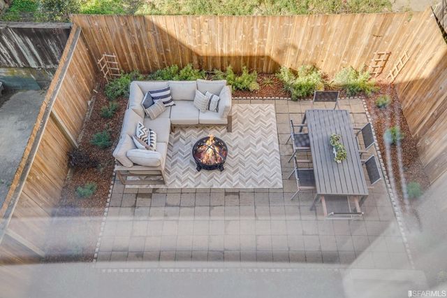 view of backyard with table and chairs and potted plants
