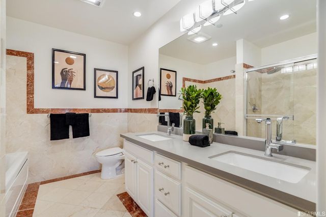 a bathroom with a double vanity sink mirror and toilet