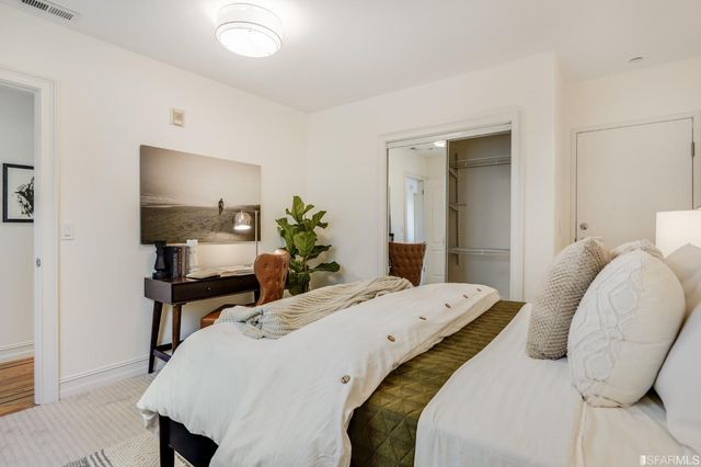 a living room with a bed furniture and a potted plant