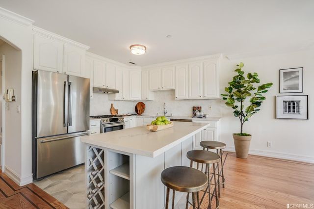 a kitchen with a refrigerator a stove a sink and a dining table