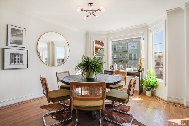a dining room with furniture a potted plant and a mirror