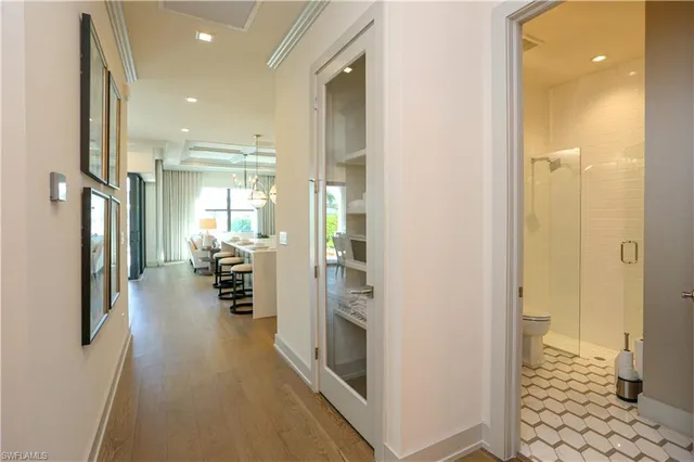 a view of a hallway with dining area and chandelier